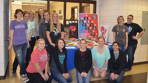 Sonography students posing with display for sonography month.