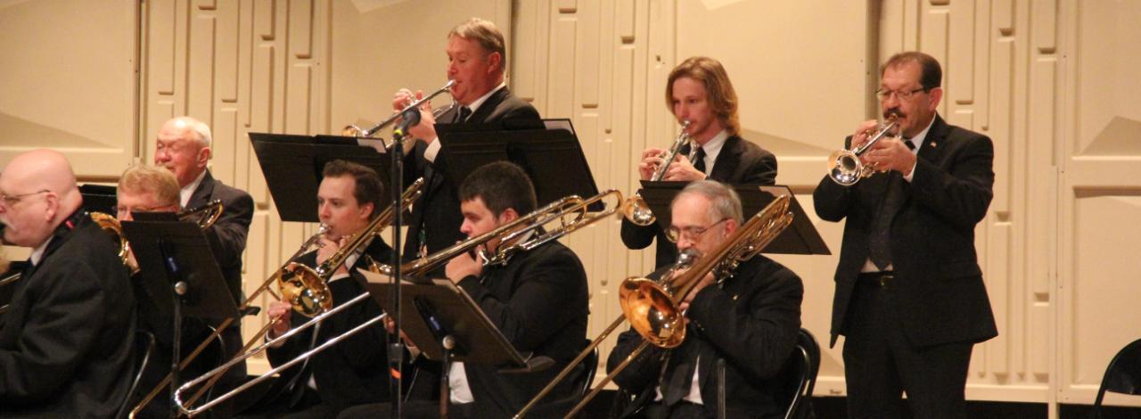 Trumpet and trombone players performing at a concert.