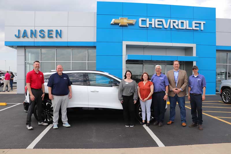 People in front of a car dealership