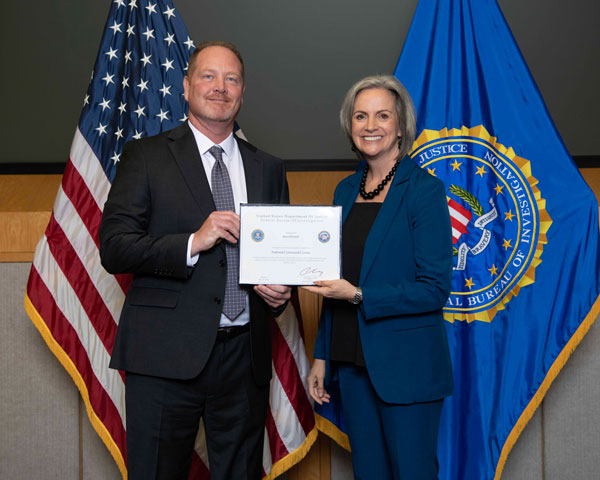 A man receiving a certificate from a woman.